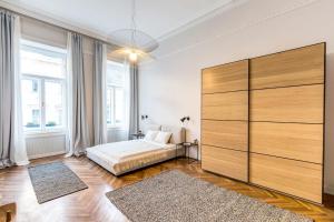 sypialnia z łóżkiem i dużą drewnianą szafką w obiekcie Designer 2 bedroom Apt-basilica 2 min walk w Budapeszcie