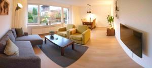 ein Wohnzimmer mit Sofa, Sesseln und Fernseher in der Unterkunft Ferienwohnung Eschenberg in Winterberg