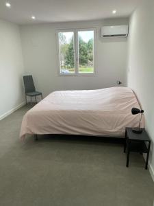 een slaapkamer met een groot bed, een bureau en een raam bij Gîte du centre equestre du val d'or in Fontaine-sur-Ay