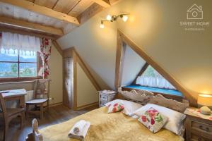 a bedroom with a bed and a desk and a window at Góralski Dwór in Kościelisko