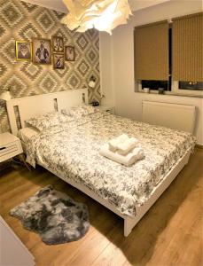 a bedroom with a bed with towels on it at Cosy Apart Busteni in Buşteni