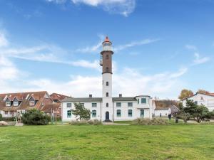 a lighthouse in front of a white building at Ferienwohnung mit Wintergarten in Wismar in Wismar