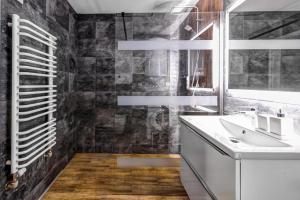 łazienka z umywalką i lustrem w obiekcie Rentimi - Apartament Kościuszki w mieście Krynica Zdrój