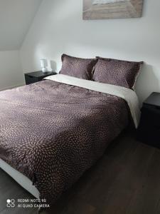 um quarto com uma cama com lençóis e almofadas roxos em TI GWEN HA DU em Locquirec