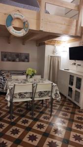 comedor con mesa y sillas y cocina en La Casetta del Tufo, en Matino