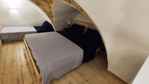 1 dormitorio con 2 camas y un arco en La Casetta del Tufo, en Matino