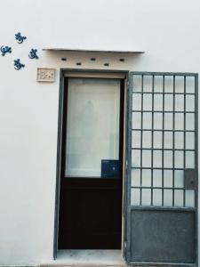 una puerta de un edificio con un cartel en la pared en La Casetta del Tufo, en Matino