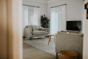 a living room with a couch and a tv at Kipdorp39 in Bree