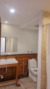 bagno con servizi igienici, lavandino e specchio di Beit Al Ward a Al Shafa