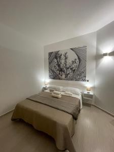 a bedroom with a bed with a painting on the wall at Casa Nicola Maria in Grottaglie