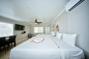 a bedroom with a large white bed with a red flower on it at Surf & Sand Hotel in Pompano Beach