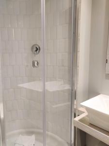 a shower with a glass door next to a sink at Corso Experience in Rome +33 photos