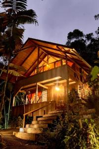 ein Haus mit einem Holzdach und einer Treppe, die dorthin führt in der Unterkunft Casa Divina Eco Lodge in Mindo