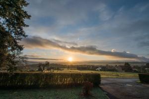 um pôr-do-sol num campo com o sol no céu em Agimon'TOIT em Hastière-par-delà