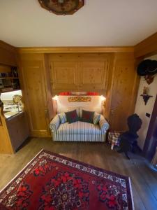 a living room with a couch and a rug at Incantevole monolocale in centro a Cortina. in Cortina dʼAmpezzo +8 photos