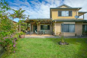 a house with a patio and a yard at Oceania Peace in Yamba