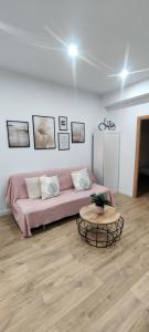 een woonkamer met een roze bank en een tafel bij New Apartment Claret in Xàtiva