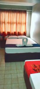 um quarto com 2 camas e uma janela em Sunseekers Outrigger Hotel em Suva