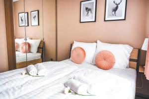 1 dormitorio con 1 cama con almohadas de color naranja y blanco en Apartament na Wzgórzu 2, Sauny, ebike, las, widok- 5D Apartamenty, en Świeradów-Zdrój