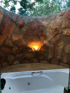 a stone wall with a bath tub in front of a stone bath tub at Villa Triacca Hotel Vinícola & Spa in Brasilia