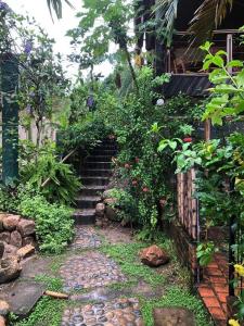 a garden with a stone path leading up to a house at Casa de Campo in Rurrenabaque
