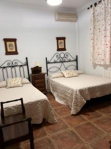 奧爾納丘埃洛斯的住宿－Casa Rural LA ENCINA，一间卧室配有两张床和一张桌子