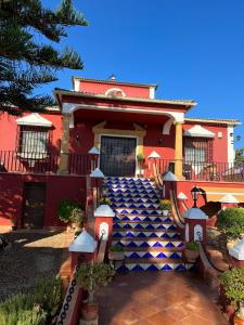 een rood huis met een blauw en wit dak bij Casa Rural LA ENCINA in Hornachuelos