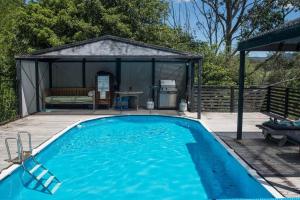 a swimming pool in front of a gazebo at Clerevale Vacation Home in Kangaroo Valley