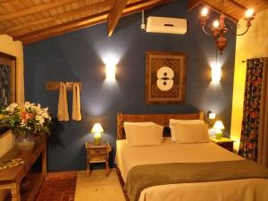 a bedroom with a bed and a blue wall at Pousada Celeiro do Gutto in Cunha +121 photos