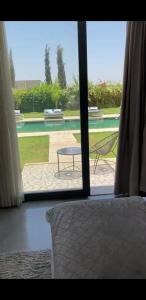 a bedroom with a bed and a view of a patio at Villa luxueuse avec piscine in Marrakesh