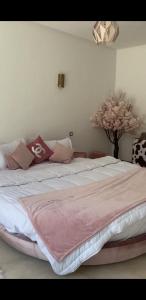 a bedroom with a large bed with a pink blanket at Villa luxueuse avec piscine in Marrakesh