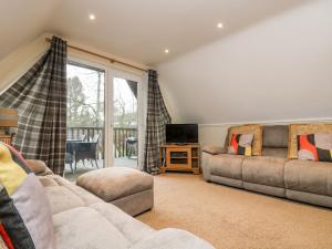 ein Wohnzimmer mit einem Sofa und einem TV in der Unterkunft Valley Lodge 31 in Callington