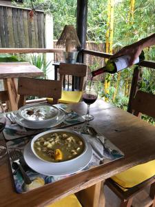 una persona che versa un bicchiere di vino su un tavolo di legno di Casa de Campo a Rurrenabaque