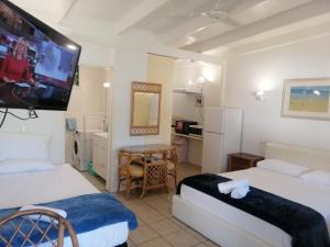 a room with two beds and a flat screen tv at Magnetic Island Resort, Sleeps 3, Free WIFI in Nelly Bay