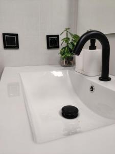 a sink with a black faucet on top of it at New Apartment Claret in Xàtiva