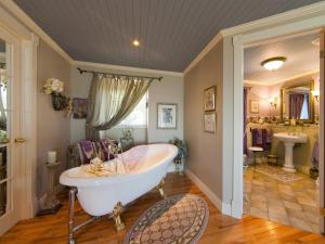 a large bathroom with a tub and two sinks at Maison Victoria in La Malbaie