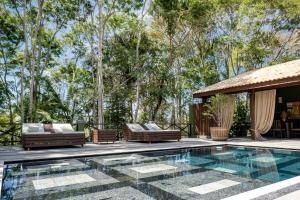 an outdoor patio with a pool and a gazebo at Pousada Celeiro do Gutto in Cunha