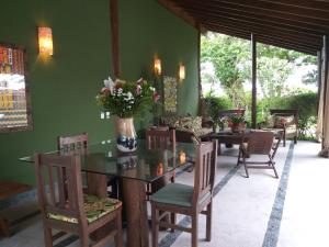 a dining room with a glass table and chairs at Pousada Celeiro do Gutto in Cunha