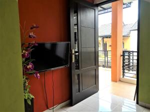 einen Fernseher an einer Wand neben einer Tür in der Unterkunft MG Villa in Tlekung