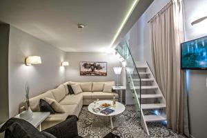 a living room with a couch and a staircase at Swell Boutique Hotel in Rethymno Town