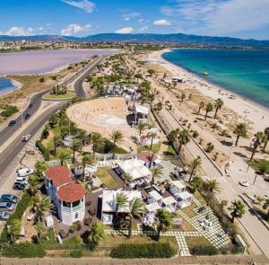 eine Luftblick auf einen Strand mit Häusern und das Meer in der Unterkunft Coru e Bentu in Quartu SantʼElena