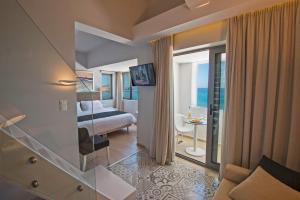 a hotel room with a bed and a view of the ocean at Swell Boutique Hotel in Rethymno Town