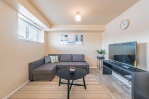 sala de estar con sofá y TV de pantalla plana en MT Pleasant NW 2 bedrooms Suite 500AB, en Calgary