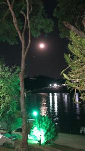 une pleine lune sur une masse d'eau la nuit dans l'établissement Pousada Paraiso de Igaratá, à Igaratá