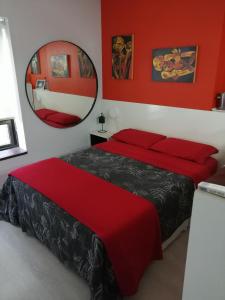 a bedroom with two beds with red walls and a mirror at Premium Down Town in Buenos Aires