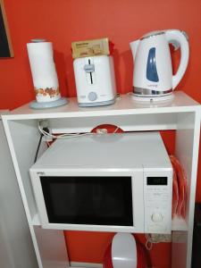 um micro-ondas numa prateleira com comodidades para preparar café em Premium Down Town em Buenos Aires