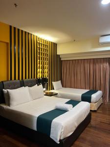 a hotel room with two beds in a room at Raintree Resort Suites in Petaling Jaya