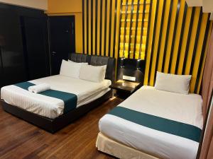 two beds in a room with two bedsskirtspectspectssenalsenalsenalsenalsenal at Raintree Resort Suites in Petaling Jaya