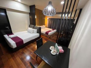 a room with two beds and a table and a dining room at Raintree Resort Suites in Petaling Jaya