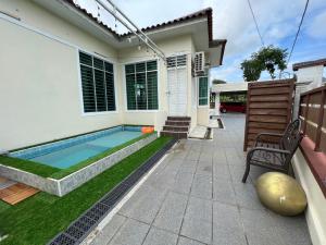 a swimming pool in the backyard of a house at AmVilla in Kota Bharu